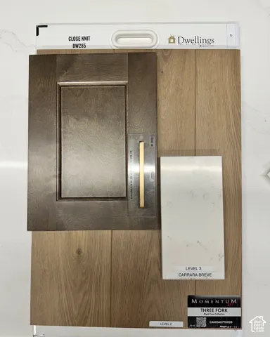 Shaker-style cabinetry featuring a deep-toned finish, complemented by straight-edge metal hardware, light-toned wood-finish flooring, and white stone surfacing with veining