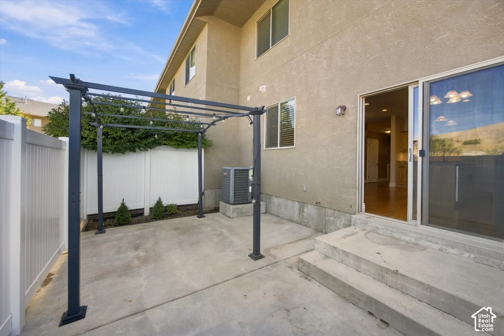 Patio with a pergola, concrete steps, sliding glass door, and a white privacy fence