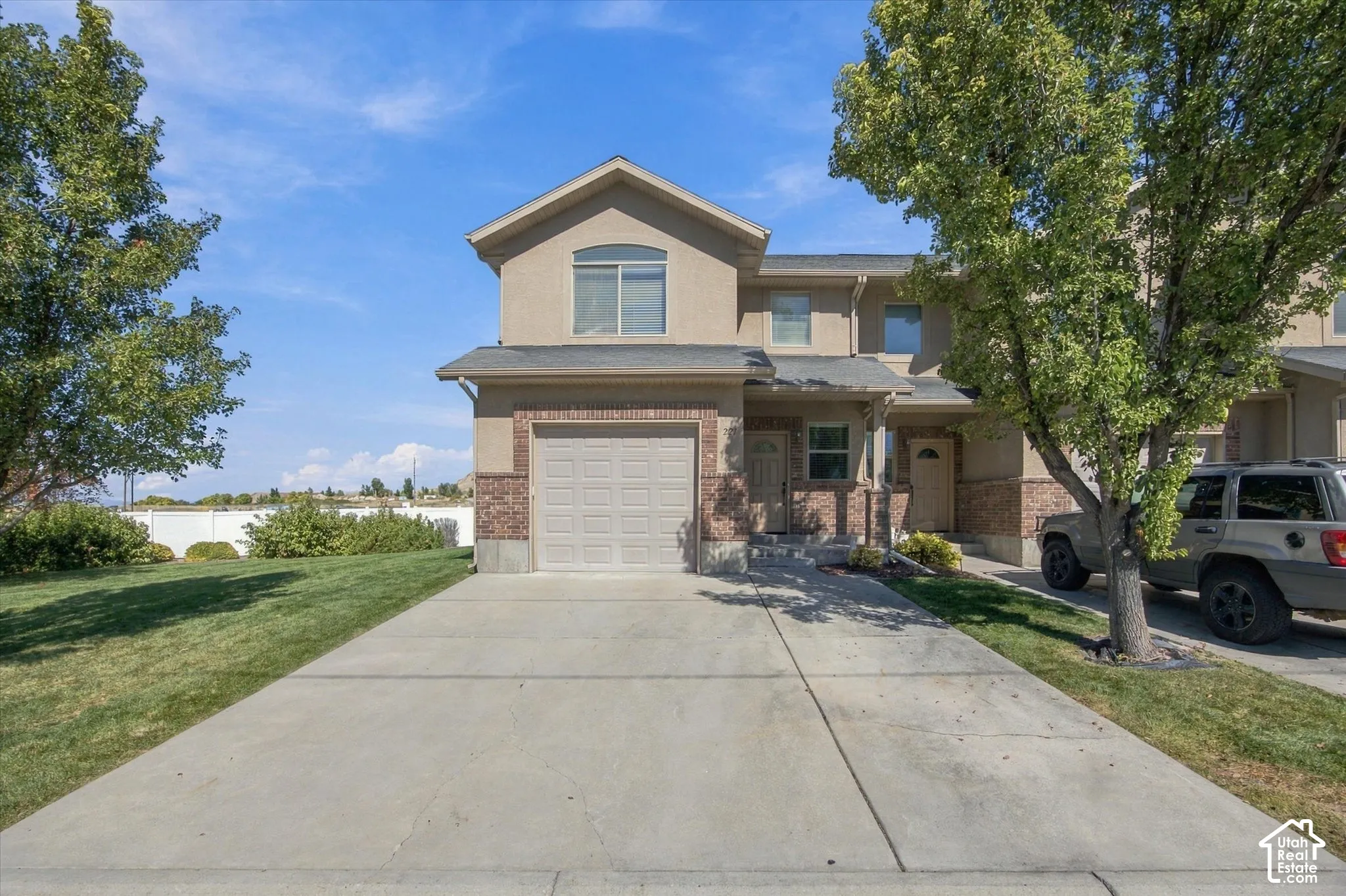 Stucco exterior with brick accents and an integrated garage