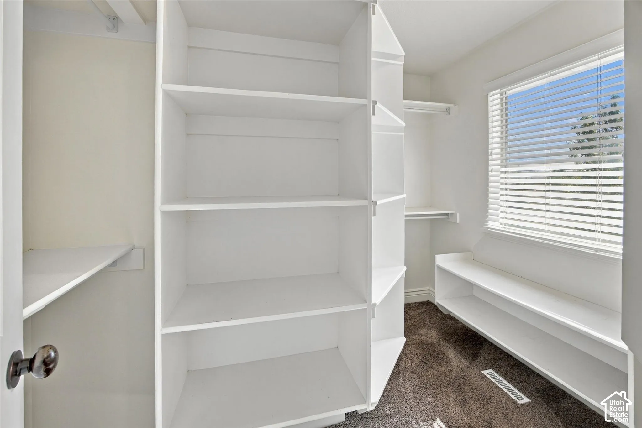 Built-in shelving, integrated storage benches, and a window with blinds