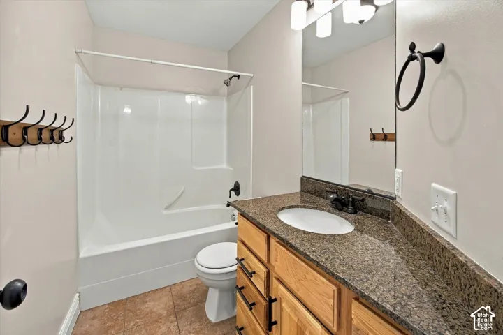 Vanity with a polished stone countertop, undermount sink, and dark bronze-finish fixtures