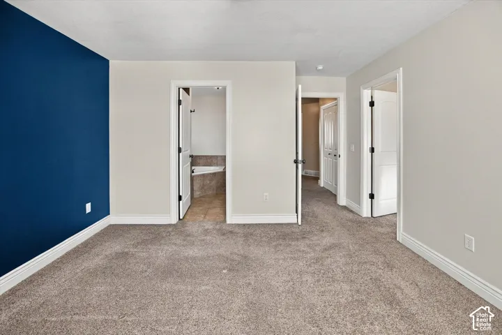 Plush carpeting throughout, white trim, and a blue accent wall