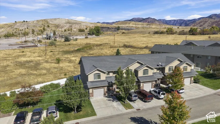 Multi-story townhomes with attached garages, brick accents, and a paved driveway