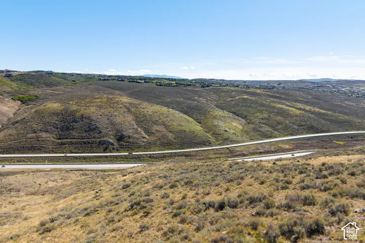Expansive undeveloped land featuring natural topography and distant residences