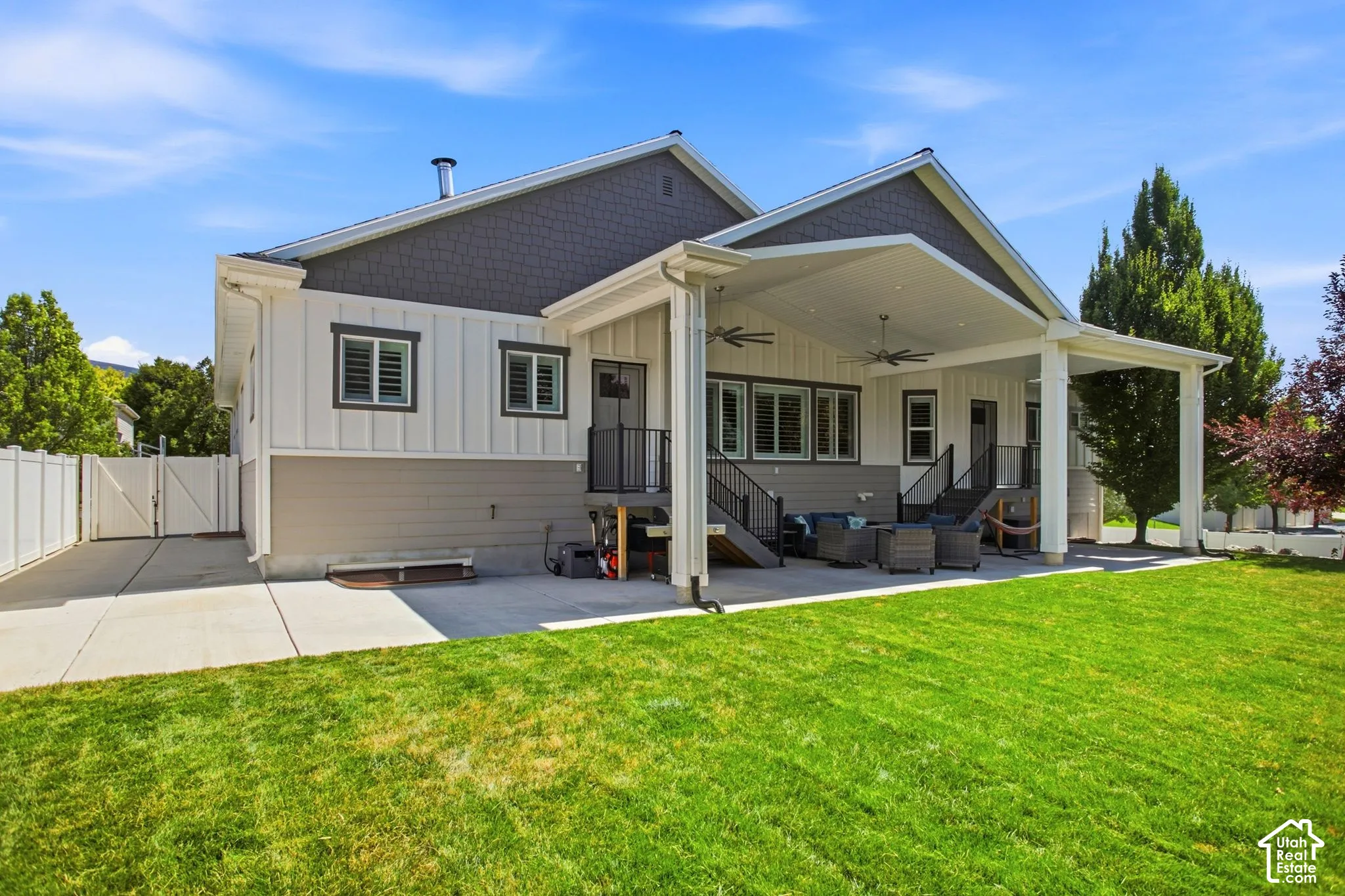 Expansive covered patio with recessed lighting and ceiling fans, and flat yard