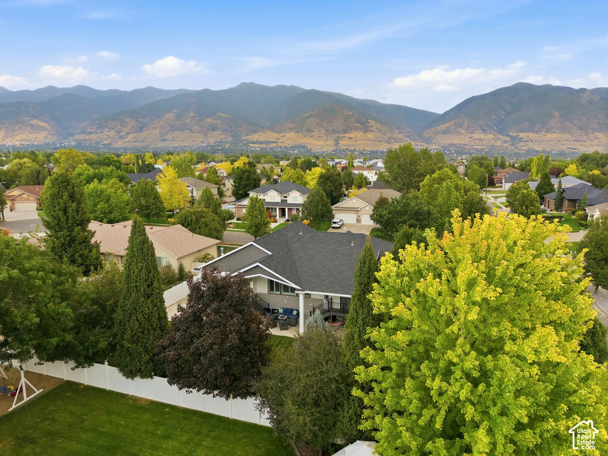 Aerial view of back of home and yard with mature trees