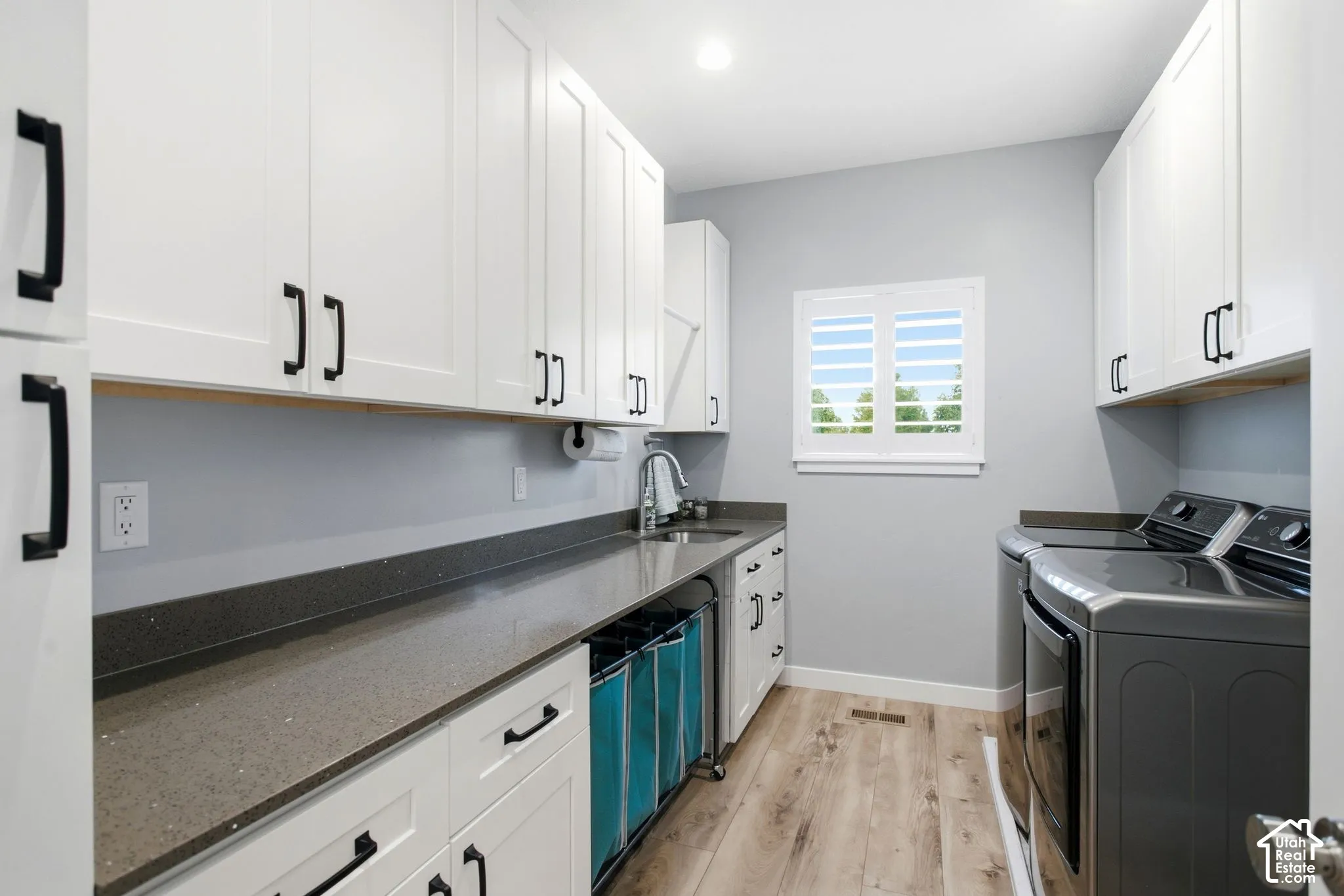 Main level laundry room with under mount sink, large folding counter and cabinets