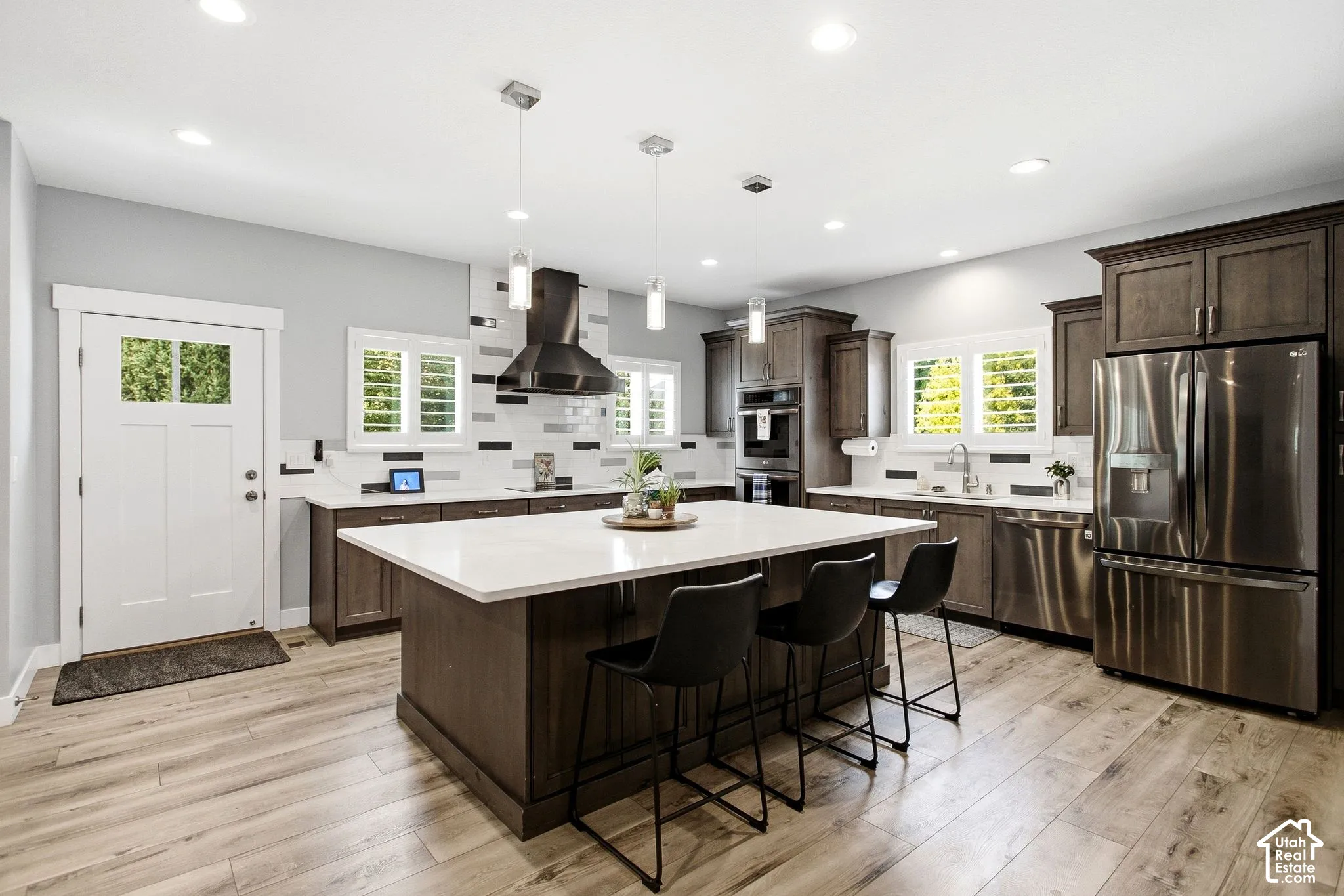 Spacious kitchen featuring an expansive Quartz island with seating, stainless steel appliances and custom cabinets