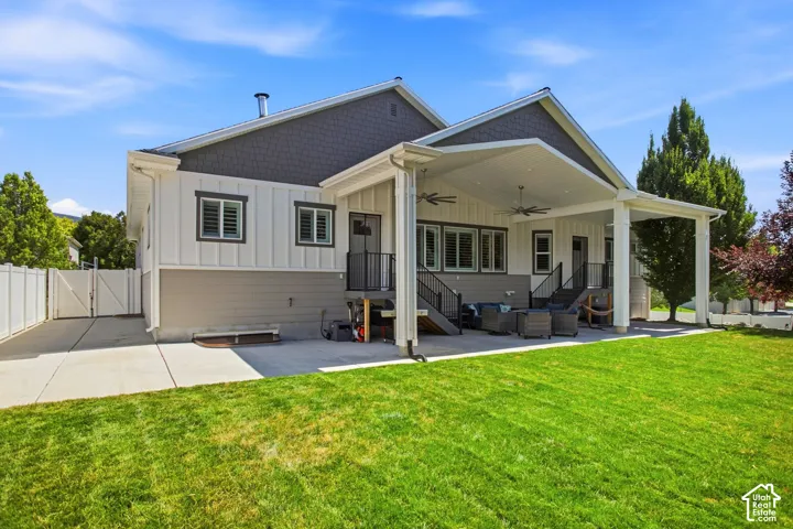 Expansive covered patio with recessed lighting and ceiling fans, and flat yard