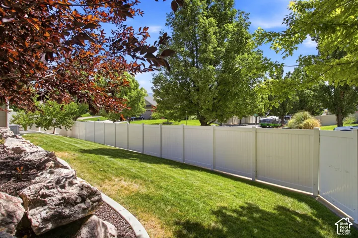 Expansive side yard with rock landscaping and a privacy fence