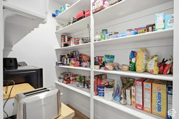 Walk-in butler pantry featuring extensive built-in shelving