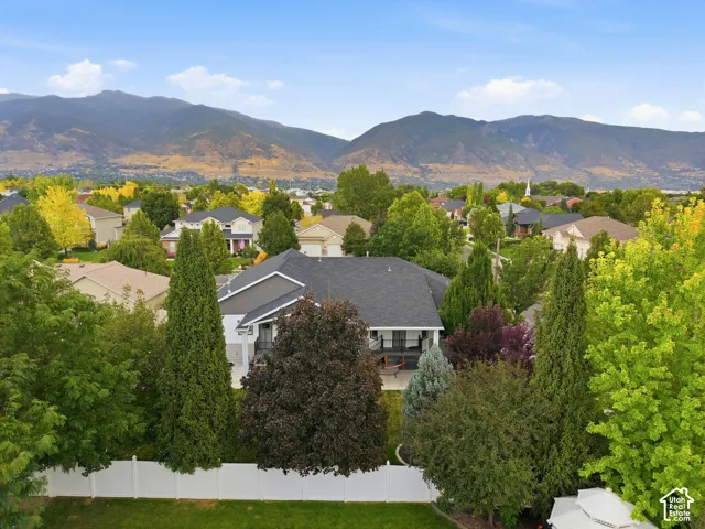 Aerial view of back of home and yard with mature trees