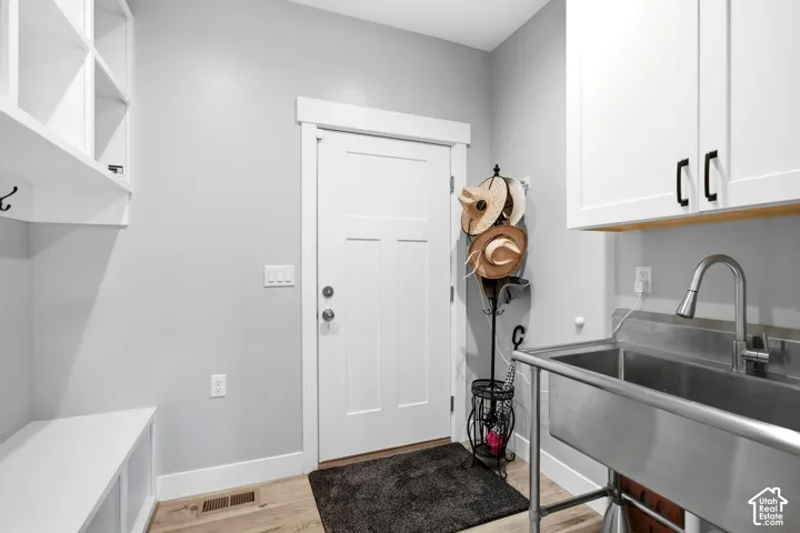 Mud room off garage with built-in cubbies and large utility sink