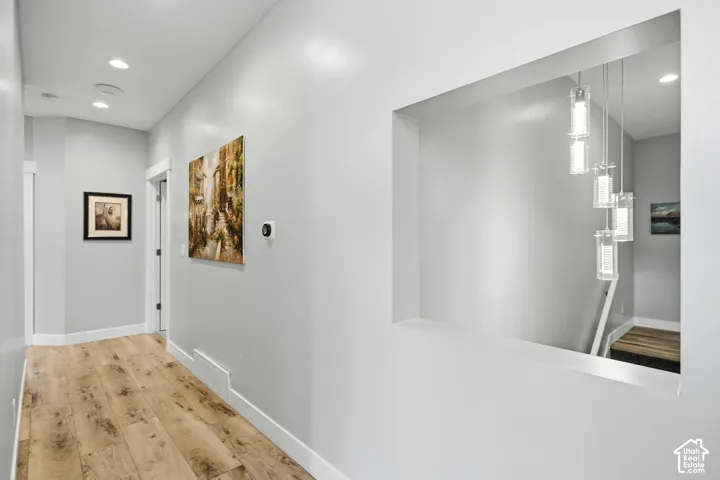 Wood-finish flooring, recessed lighting, and view of stairs going down to lower level