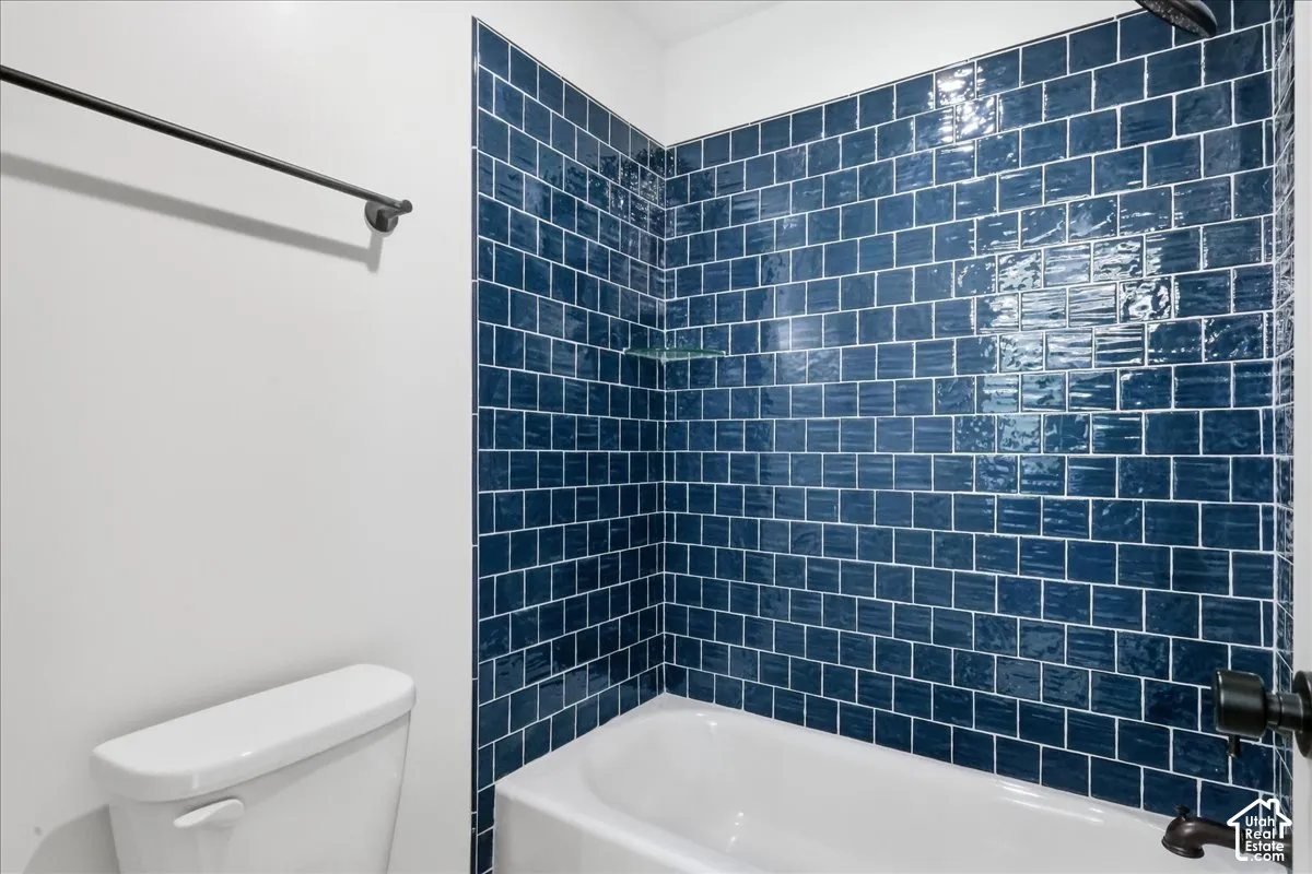 Jack n Jill bathroom Built-in bathtub with subway tile surround, matte black shower fixtures, and a glass shelf