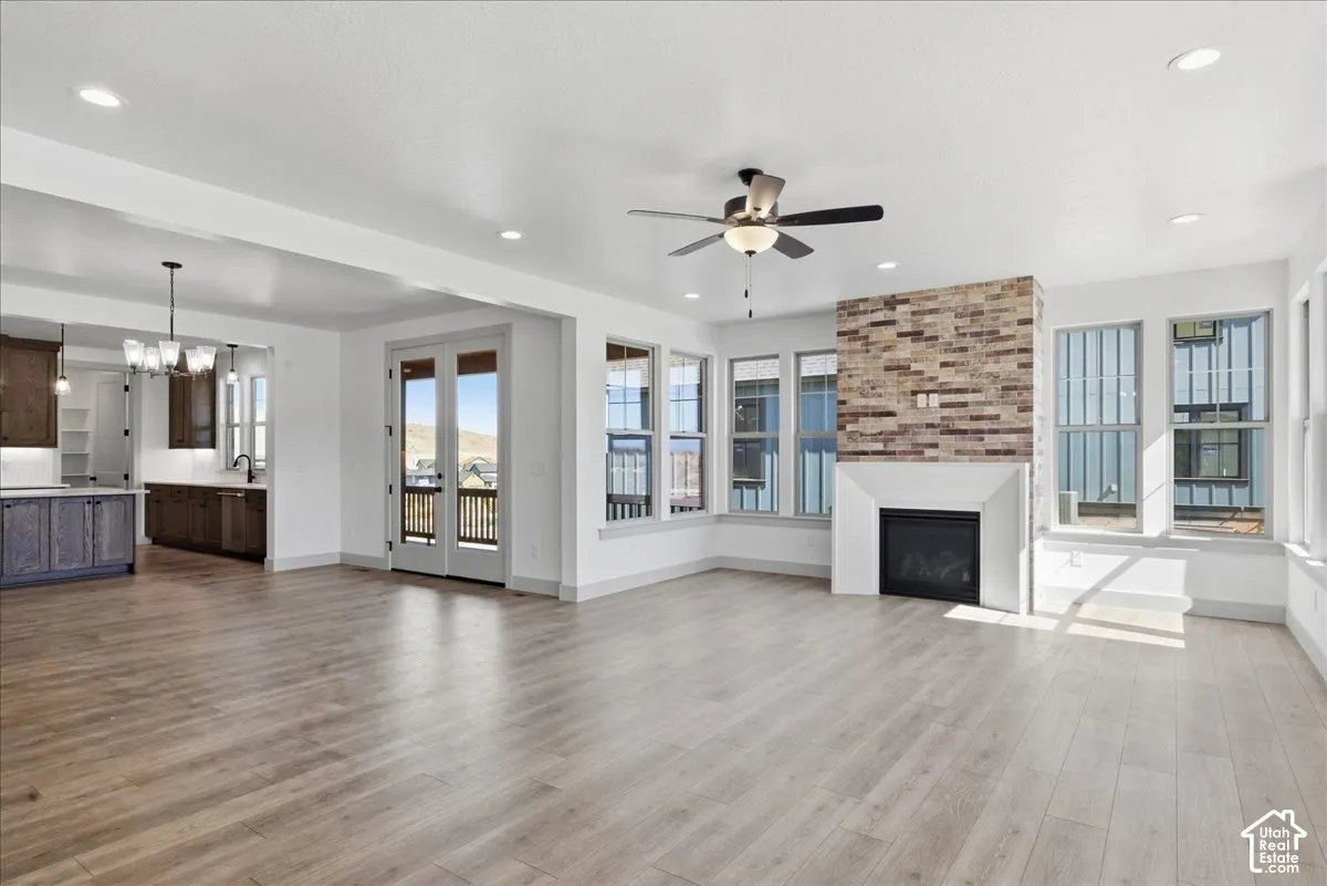 Spacious living area featuring wood-finish flooring, a ceiling fan, and recessed lighting