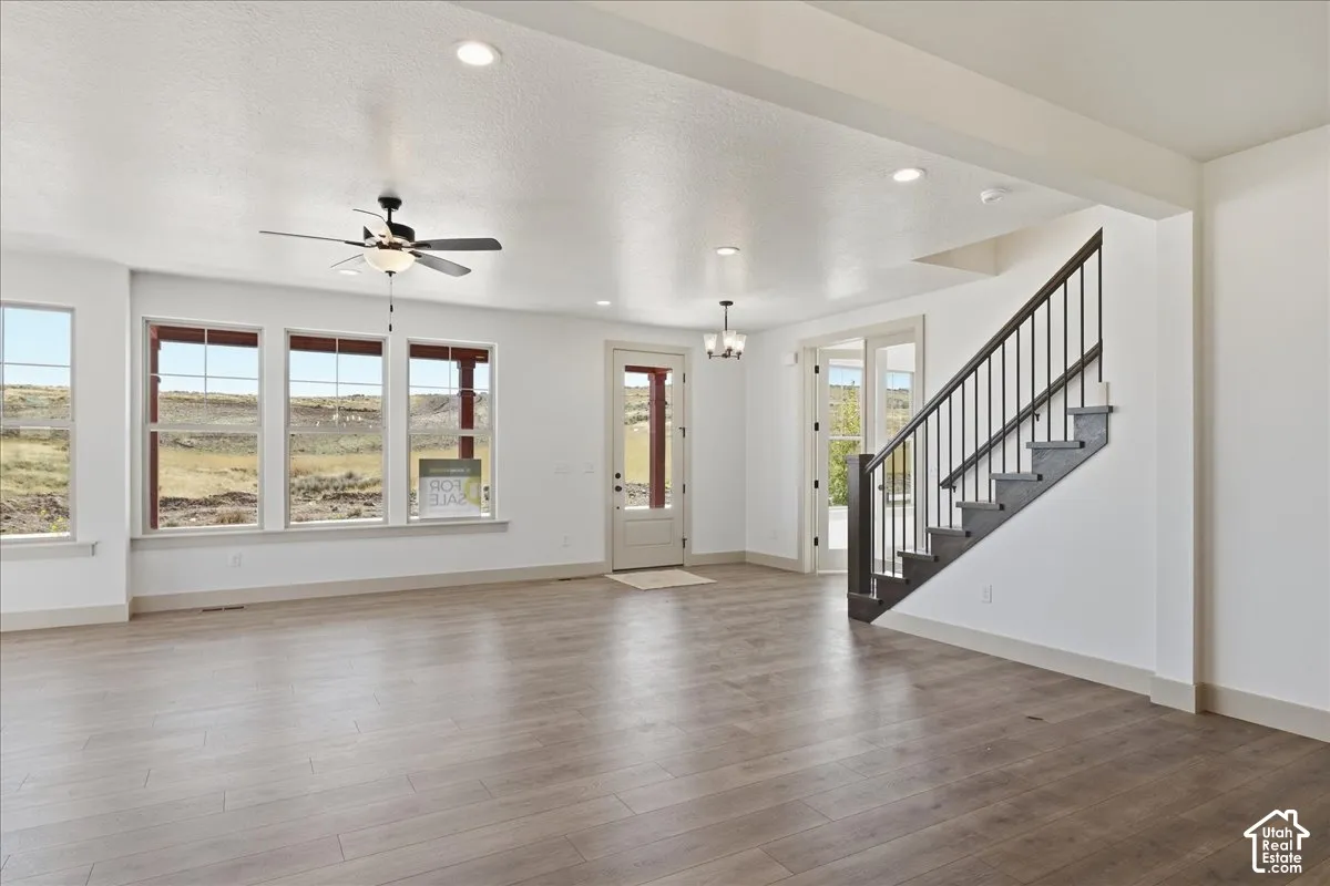 Open-concept living area with wood-finish flooring, recessed lighting, and a contemporary ceiling fan