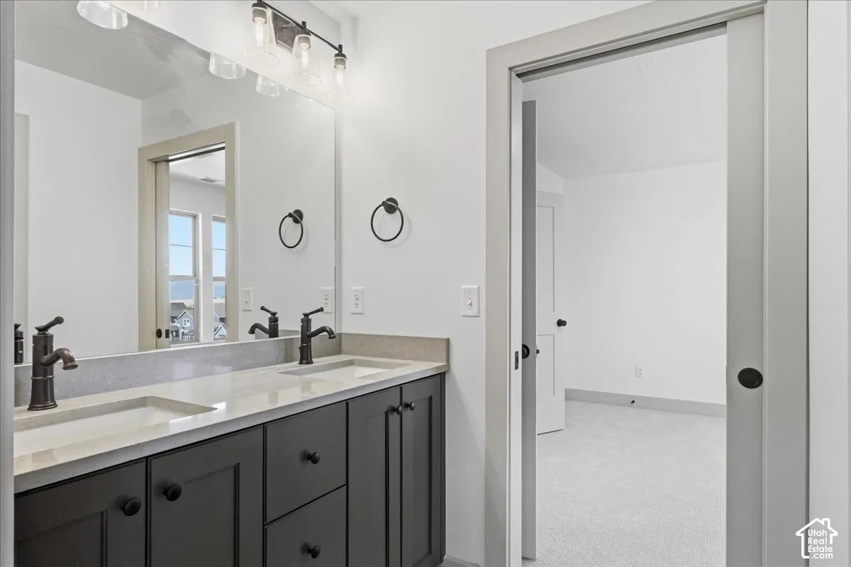 Jack n Jill bathroom Dual vanity with light-toned countertop, dark cabinetry, and bronze-finish fixtures