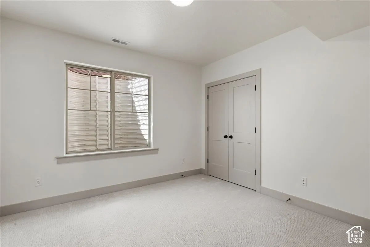 Recessed ceiling light, neutral wall paint, two-panel interior doors, modern door hardware, window well