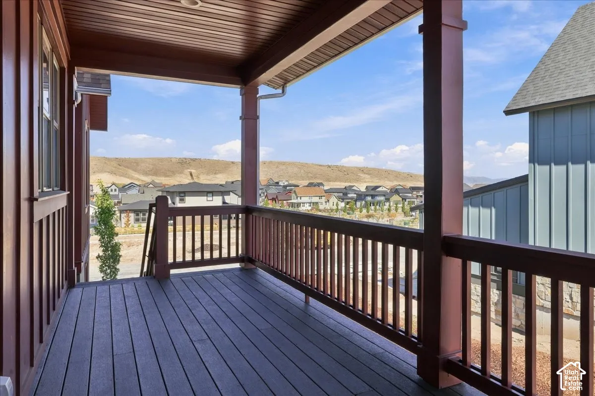 Expansive covered deck featuring composite decking, painted wood railings, and a wood-finish ceiling