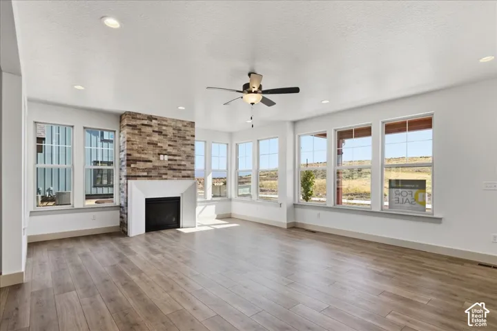 Spacious interior with extensive wood-finish flooring, recessed lighting, and a ceiling fan