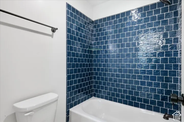 Jack n Jill bathroom Built-in bathtub with subway tile surround, matte black shower fixtures, and a glass shelf