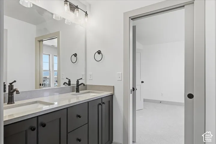 Jack n Jill bathroom Dual vanity with light-toned countertop, dark cabinetry, and bronze-finish fixtures
