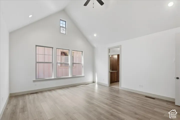 Vaulted ceiling with recessed lighting and a ceiling fan