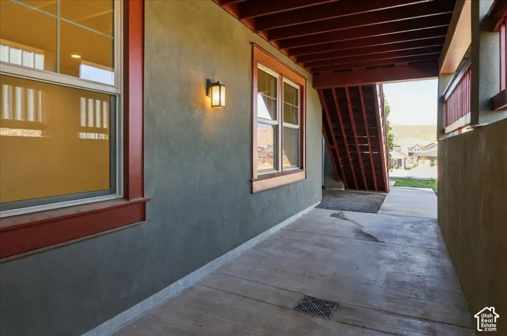 Stucco exterior with contrasting trim, concrete patio, and exterior wall-mounted lighting