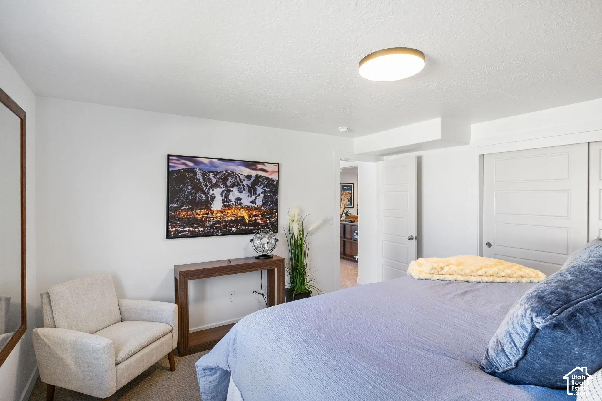 Recessed lighting, wood-finish console table, flat panel sliding closet doors, wall-mounted light fixture, and light-colored carpeting