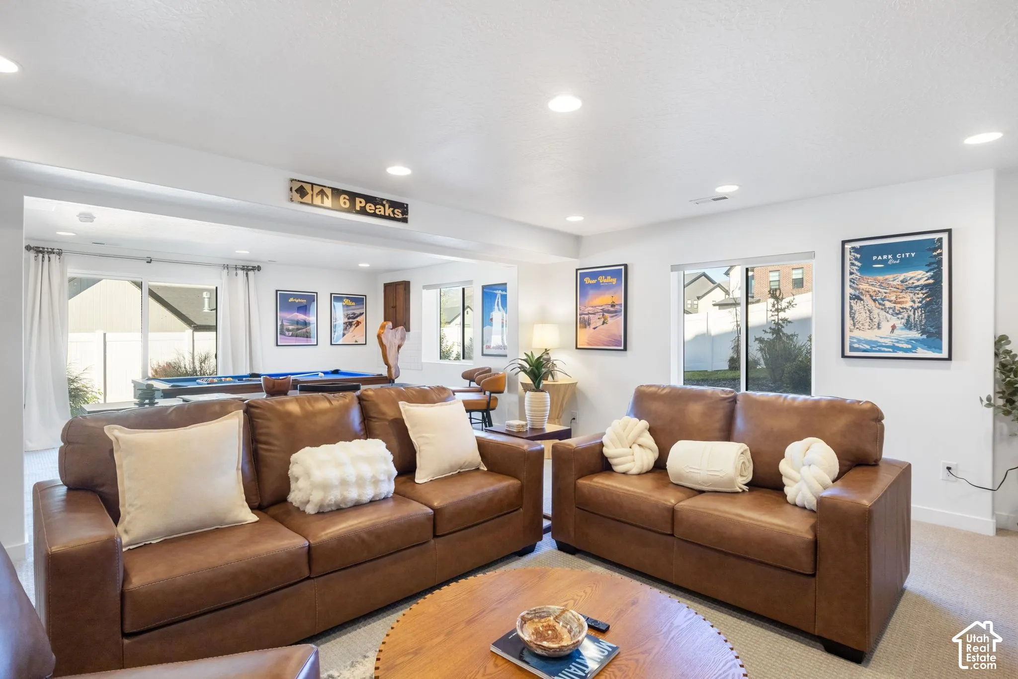 Recessed lighting, white walls, multiple windows, and light-toned carpeting
