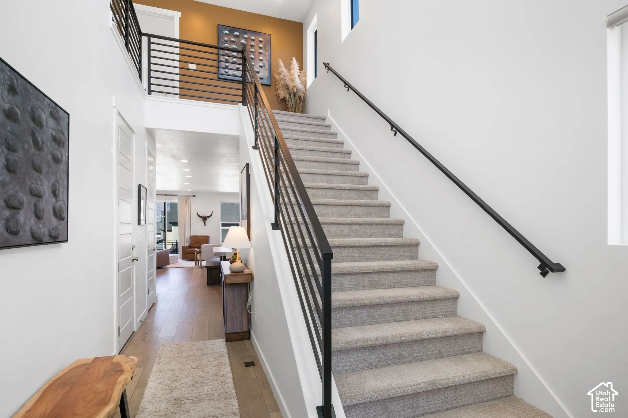 Staircase with carpeted treads and contemporary black metal railings