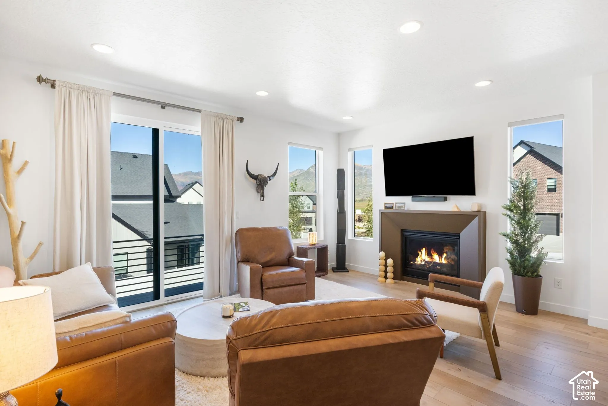 Living area featuring a gas fireplace, wood-finish flooring, recessed lighting, and large sliding glass doors
