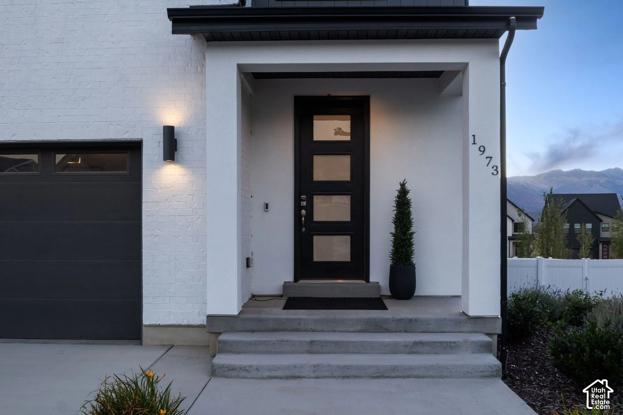 White brick exterior with a dark-paneled garage door