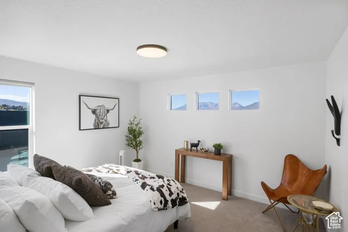 Bright room with white walls, a large window, three smaller square windows, and a flush-mount ceiling light