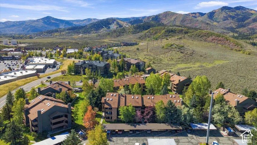 Multi-story structures with extensive landscaping, covered parking, and mountain scenery