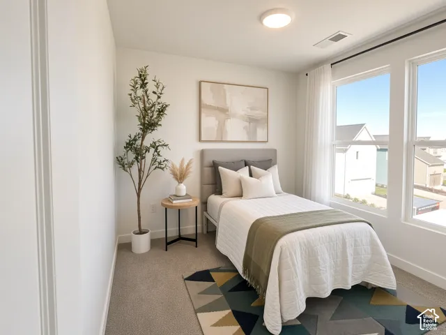 Recessed lighting, large windows, and neutral carpeting