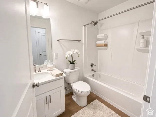 Bathroom featuring a single vanity with storage, a white countertop, and a built-in tub with a shower