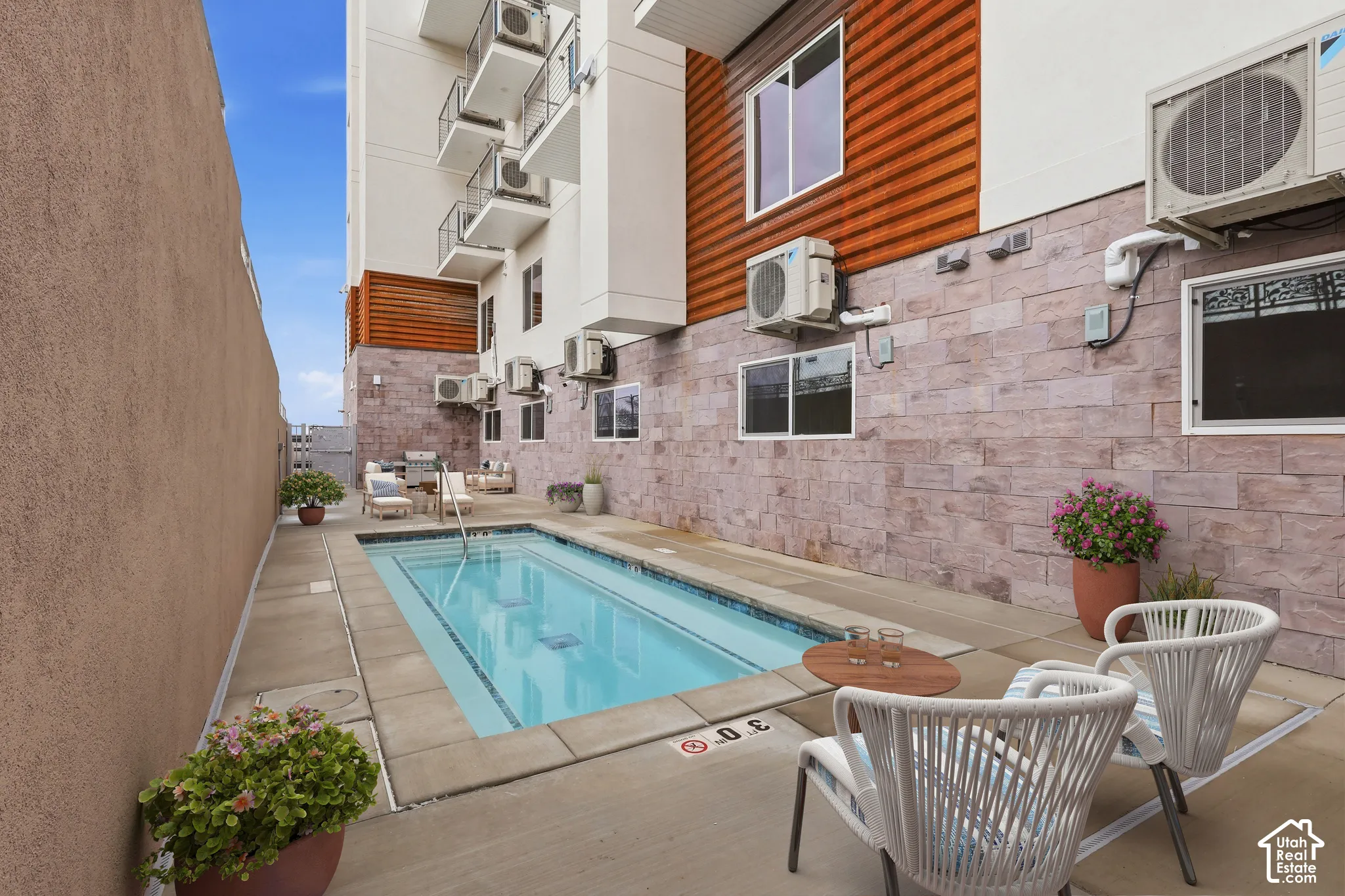 Compact swimming pool with integrated spa and concrete surround
