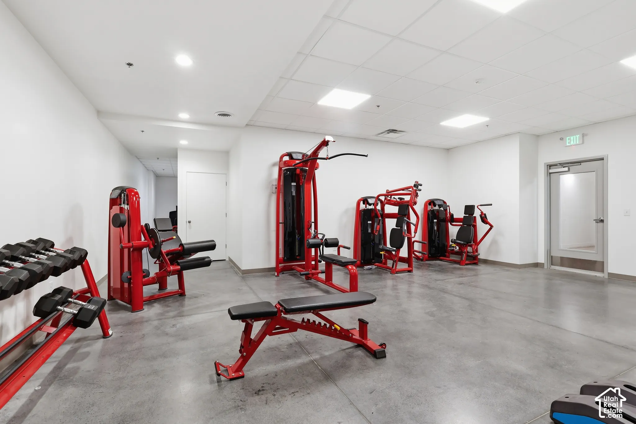 Fitness center featuring concrete flooring, white walls, recessed lighting, and gym equipment