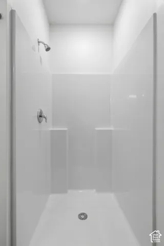 White shower stall with a polished chrome shower head and fixture
