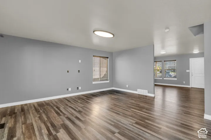 Wood-finish flooring, recessed lighting, and a white interior door