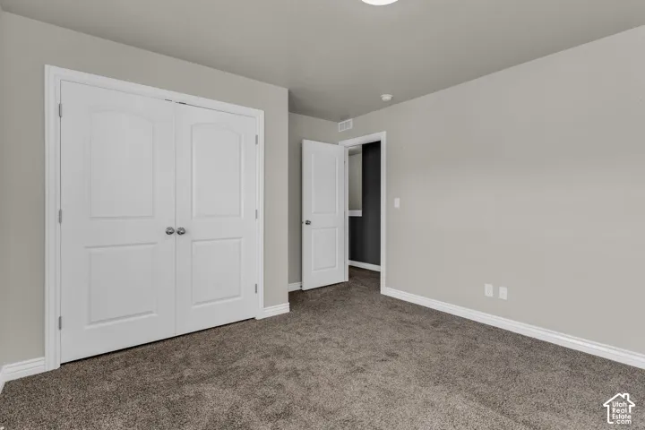 Neutral wall palette, plush carpet flooring, white trim, and white bi-fold doors