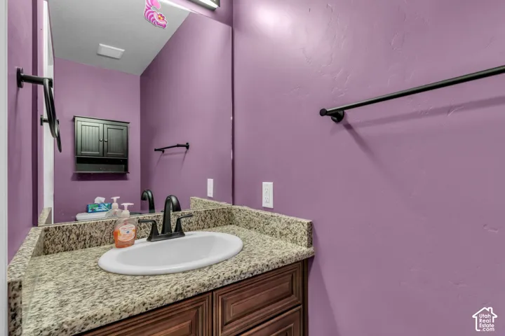 Vanity with granite countertop, integrated oval sink, and dark bronze-finish faucet