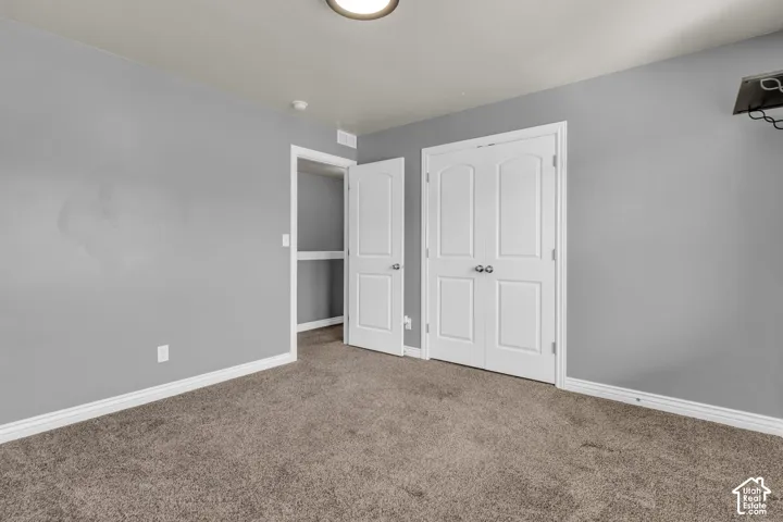 Carpeted flooring, neutral wall color, white trim, and white paneled doors