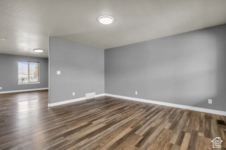 Wood-finish flooring, recessed lighting, neutral gray walls, and white trim