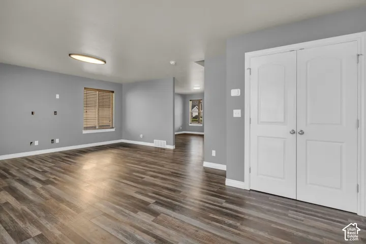 Wood-finish flooring, light gray wall tones, white trim, and a window with wood blinds