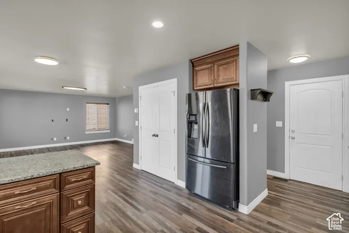Wood-finish flooring throughout, complemented by a kitchen island with stone countertop