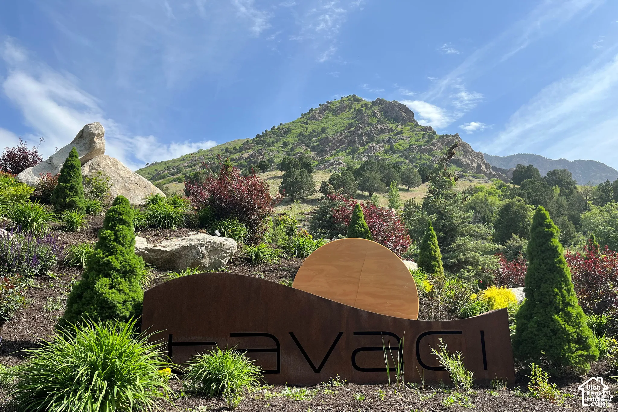 Hillside landscaping featuring diverse plantings and prominent rock formations
