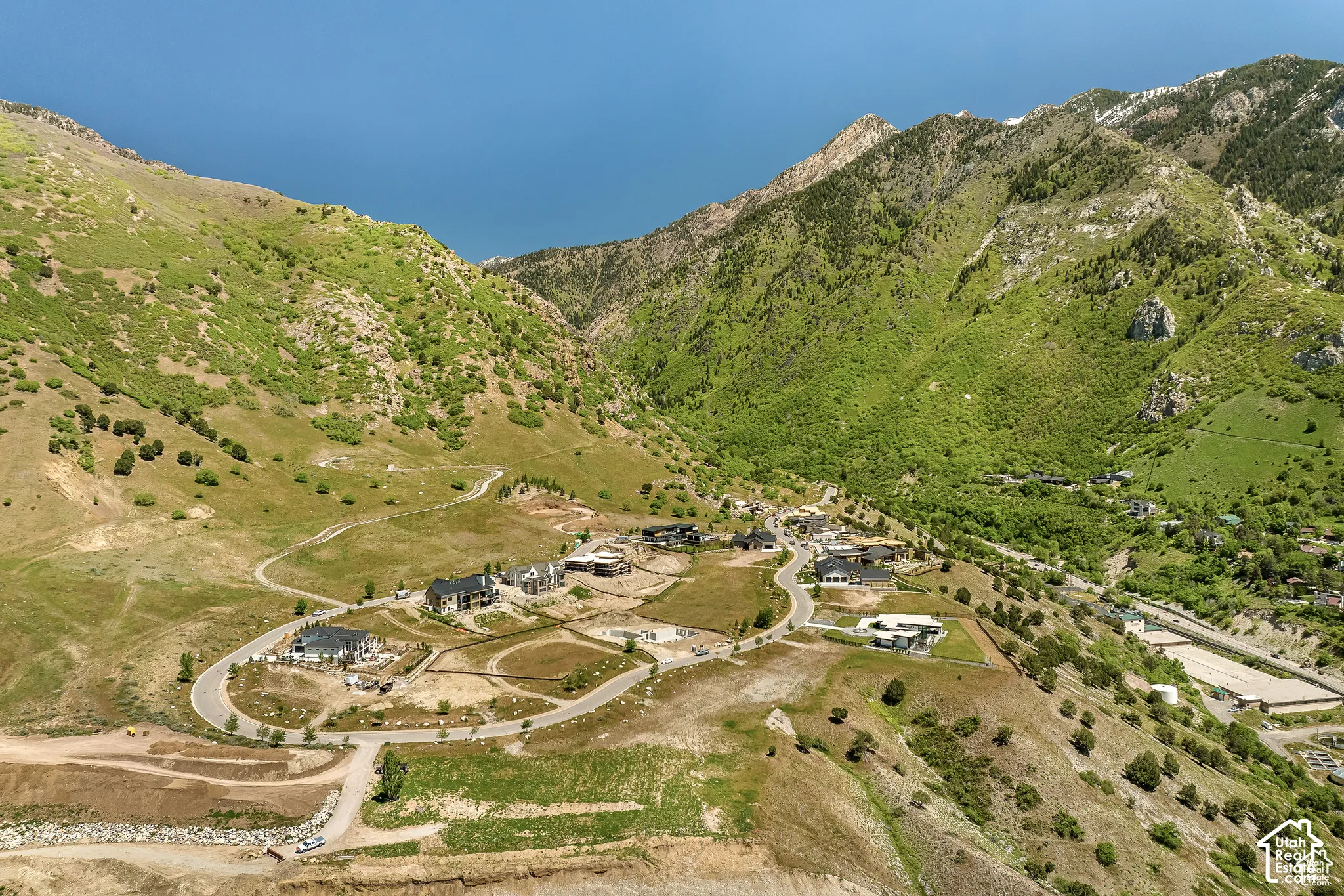 Expansive mountain-side property featuring multiple dwellings, winding roads, and a verdant landscape